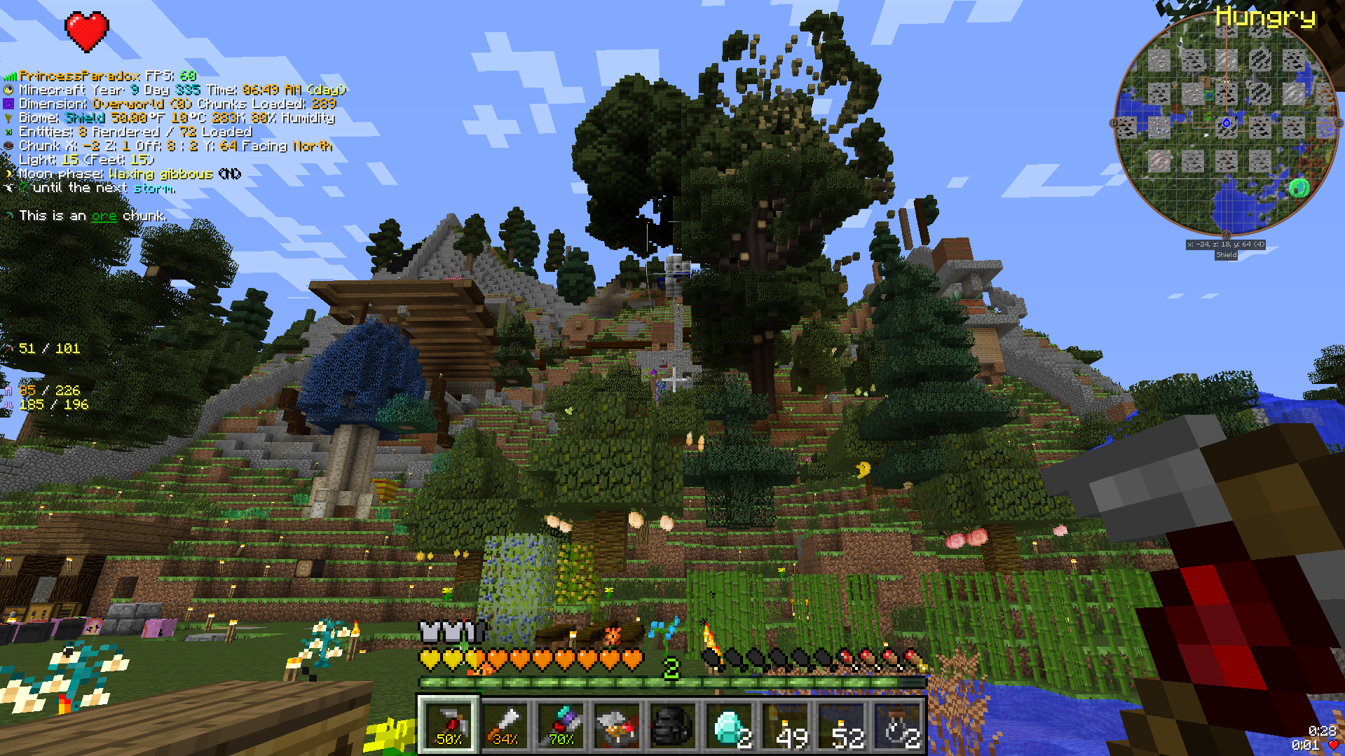 A view of the main base in one of the Minecraft Club’s servers. From left to right: farm equipment, an apothecary building, a lab building, the “sacred oak” treetops and the old blast furnace.